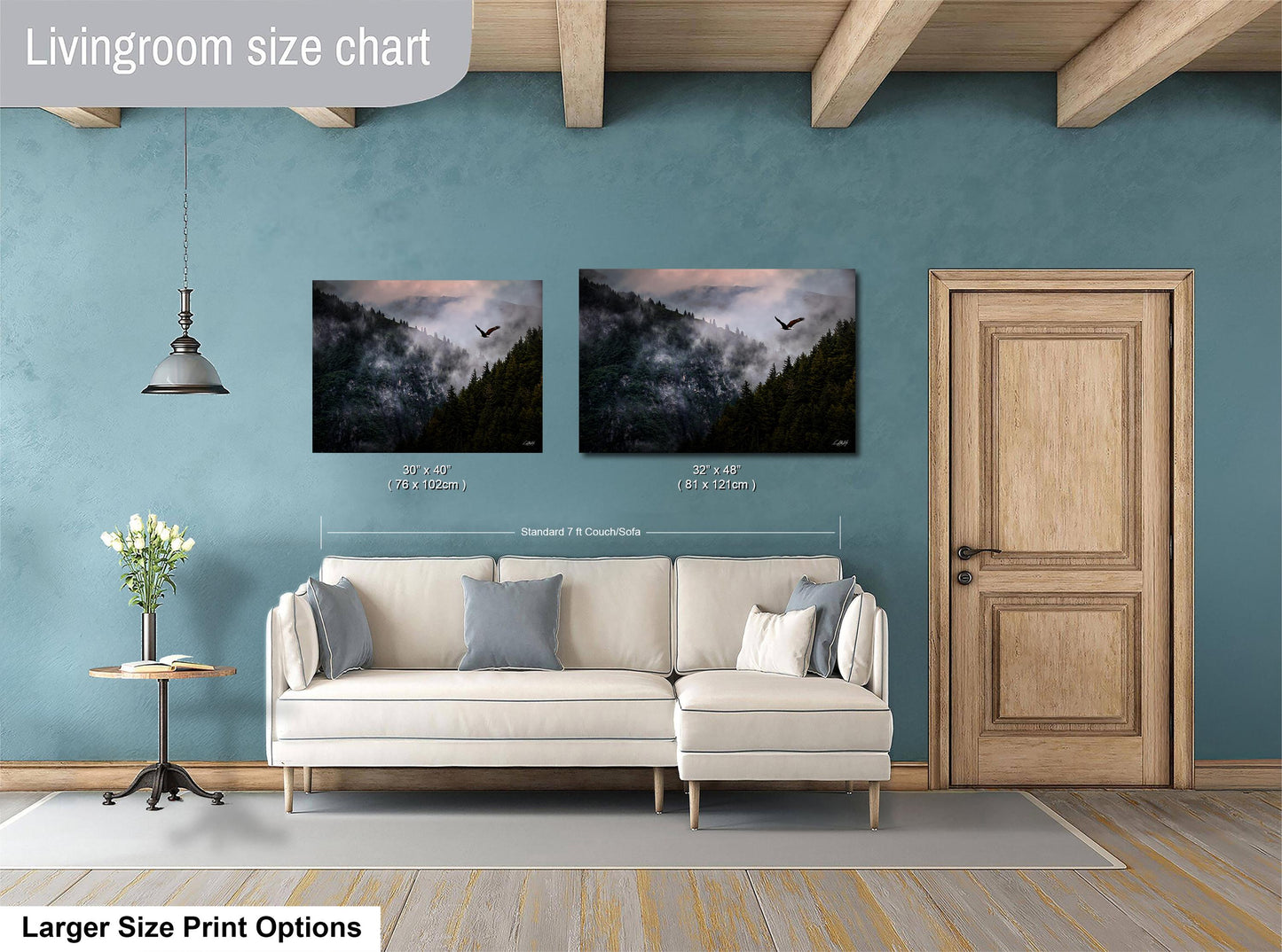 a living room with a white sofa, a wooden door, and two framed landscape paintings hanging on the wall.