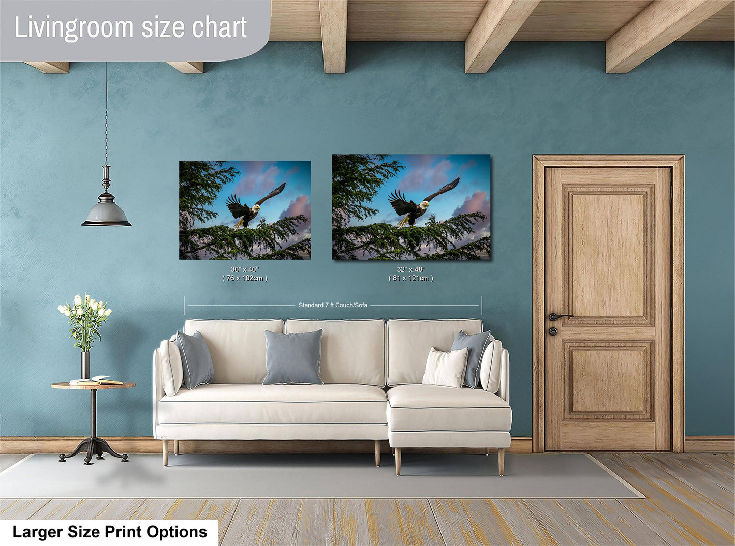 a living room with a white sofa, a wooden door, and two framed pictures of a bald eagle perched on a tree branch. The living room appears to be well-lit and decorated with a vase of flowers on a table.