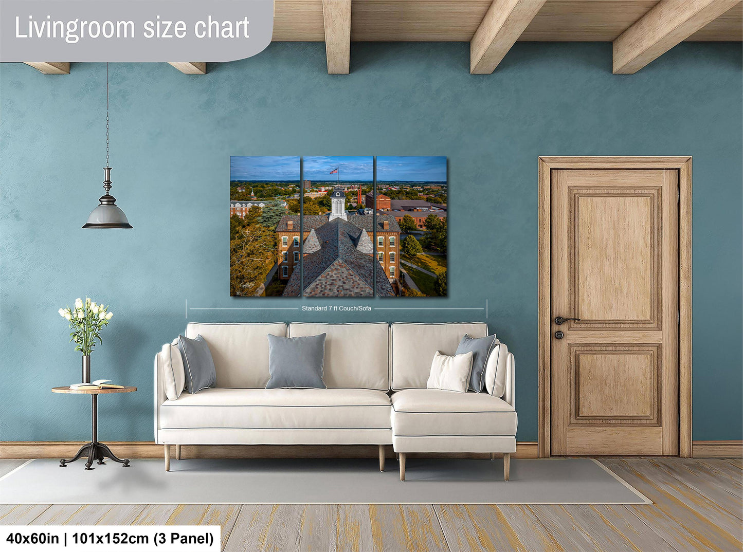 The image is a living room with a large white sofa, a wooden door, and a painting of a building on the wall.