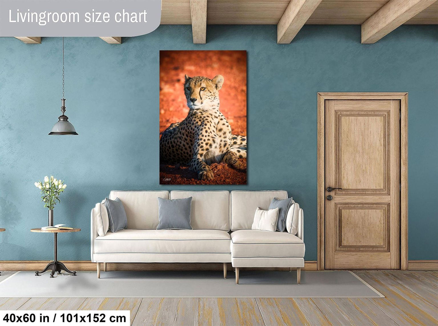 a living room with a large white sofa, a wooden door, and a framed photograph of a cheetah on the wall.