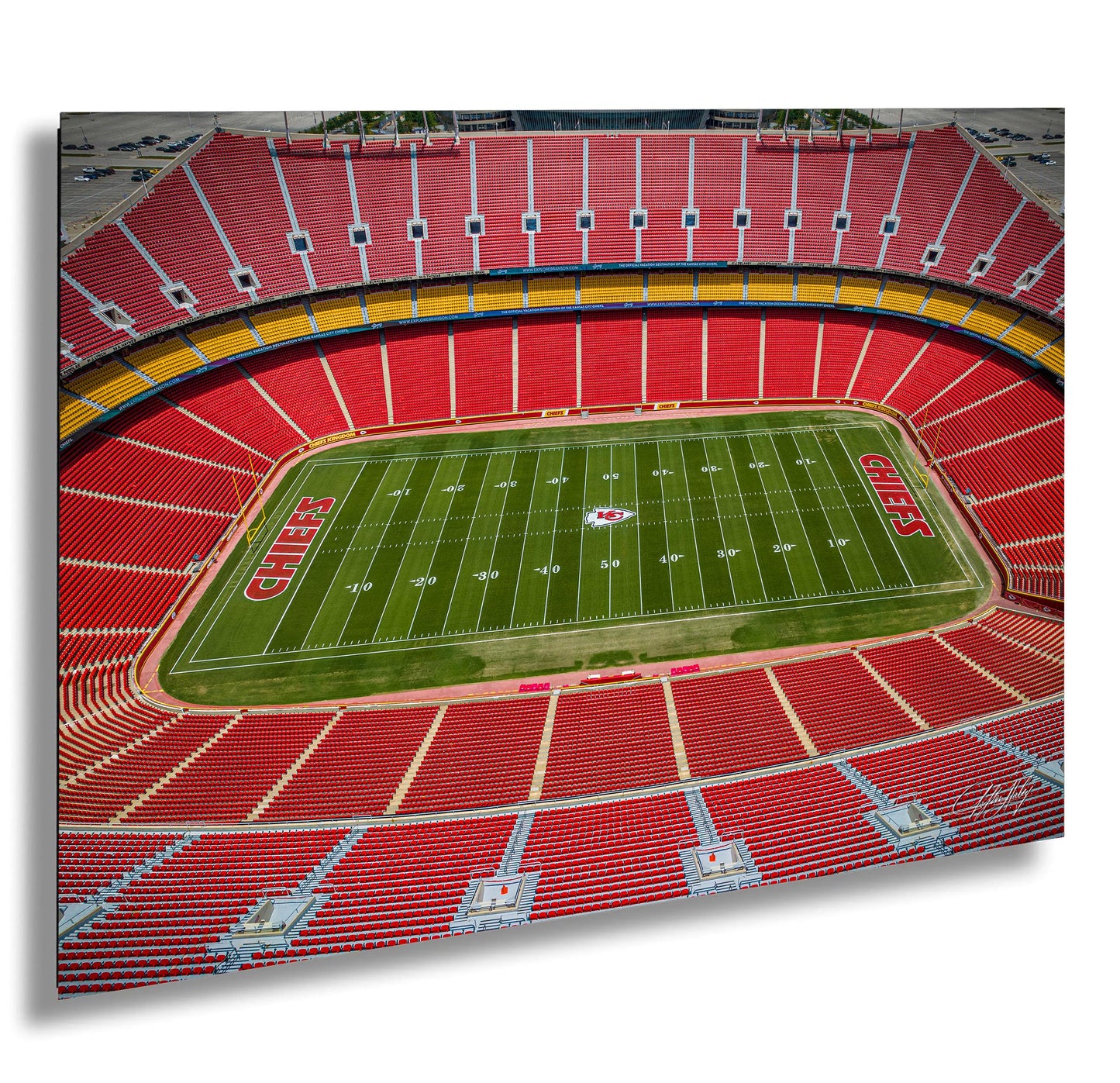 an aerial view of a football stadium with a large field and rows of red seats.