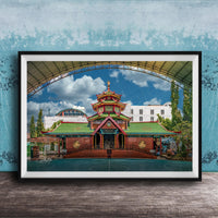 A framed photograph of a traditional Chinese temple with a red roof and green walls, set against a blue sky with clouds.