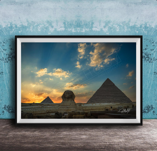 the Great Pyramids of Giza against a stunning sunset sky, with the Sphinx in the foreground.