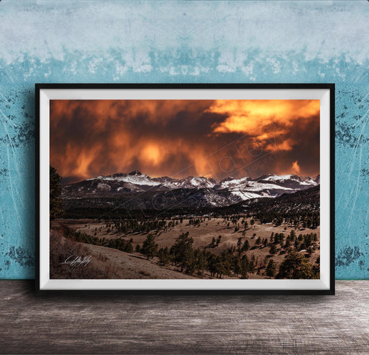 a breathtaking mountain landscape with a dramatic sky filled with clouds and fiery orange hues, creating a stunning and awe-inspiring scene.