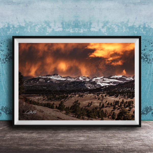 a breathtaking mountain landscape with a dramatic sky filled with clouds and fiery orange hues, creating a stunning and awe-inspiring scene.