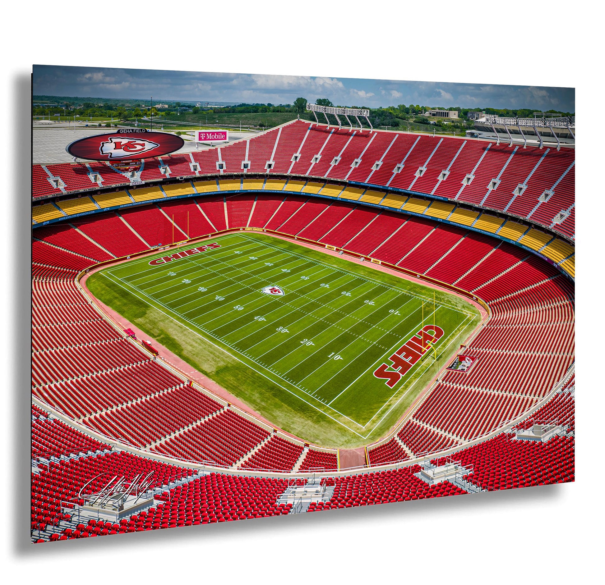 a large football stadium with a green field and red seating.