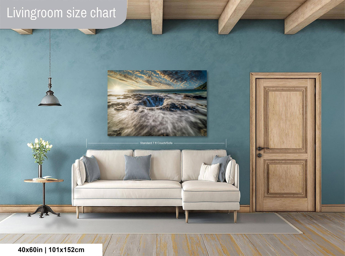 a living room with a large white sofa, a wooden door, and a painting of a beach scene hanging on the wall.