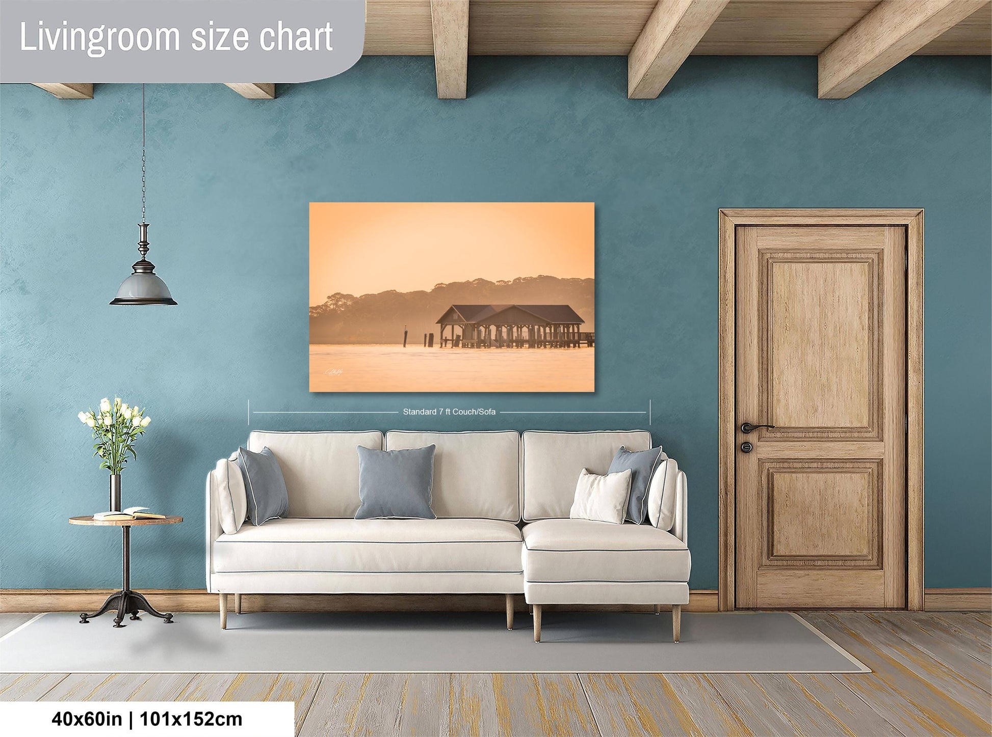 a living room with a white sofa, a wooden door, and a painting of a house on the wall.