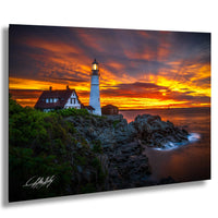 A picturesque lighthouse stands on a rocky cliff, overlooking the ocean at sunset. The sky is filled with vibrant orange and yellow hues, creating a stunning backdrop for the lighthouse. The image is a captivating blend of natural beauty and architectural charm.