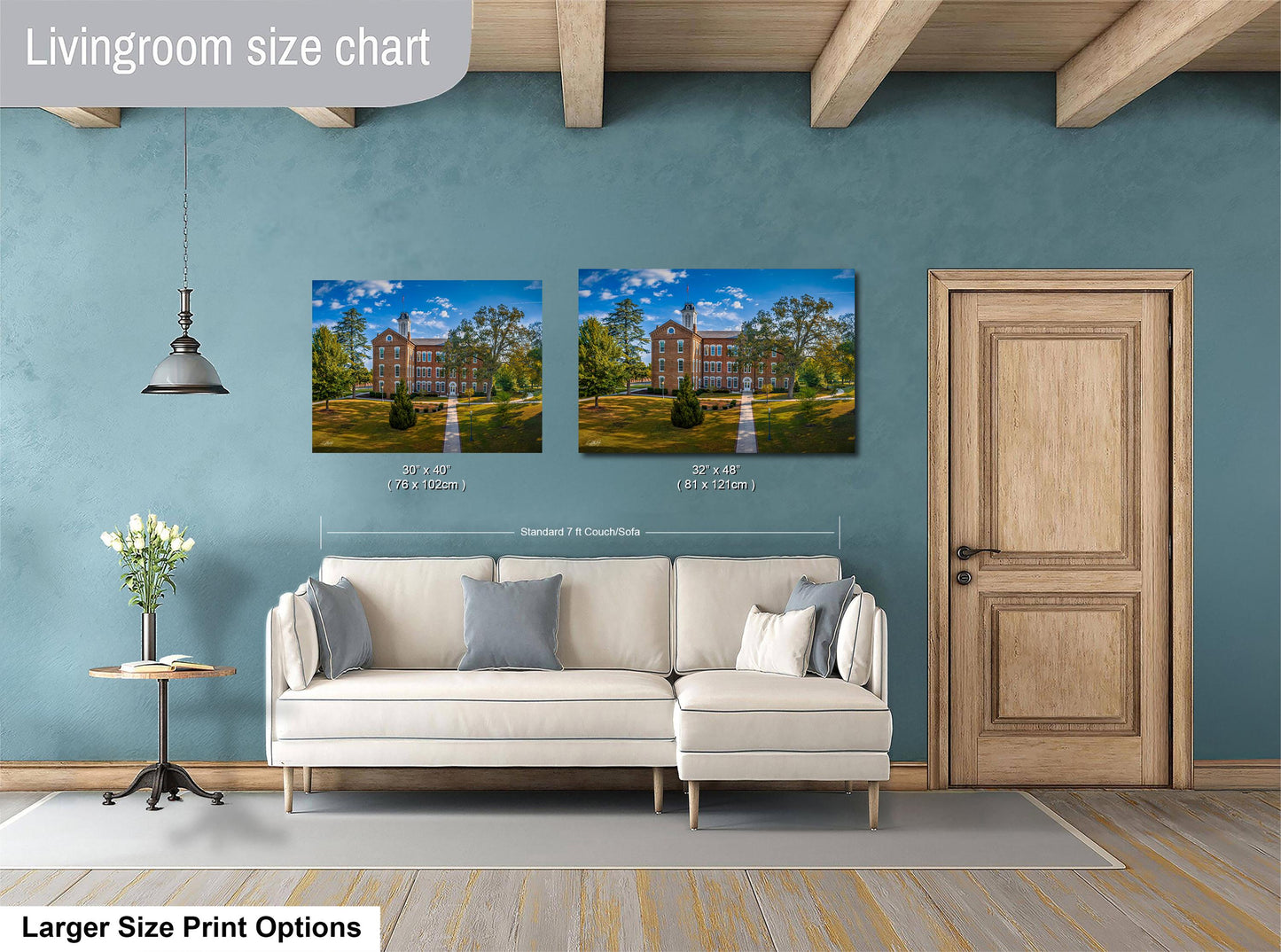 a living room with a white sofa and a wooden door. Above the sofa, there are two framed pictures of a building, likely a college campus, displayed on the wall. The wall is painted a light blue color, and there is a lamp hanging from the ceiling. The image also includes text that provides size information for the framed pictures, indicating that they are 30x42 inches in size.