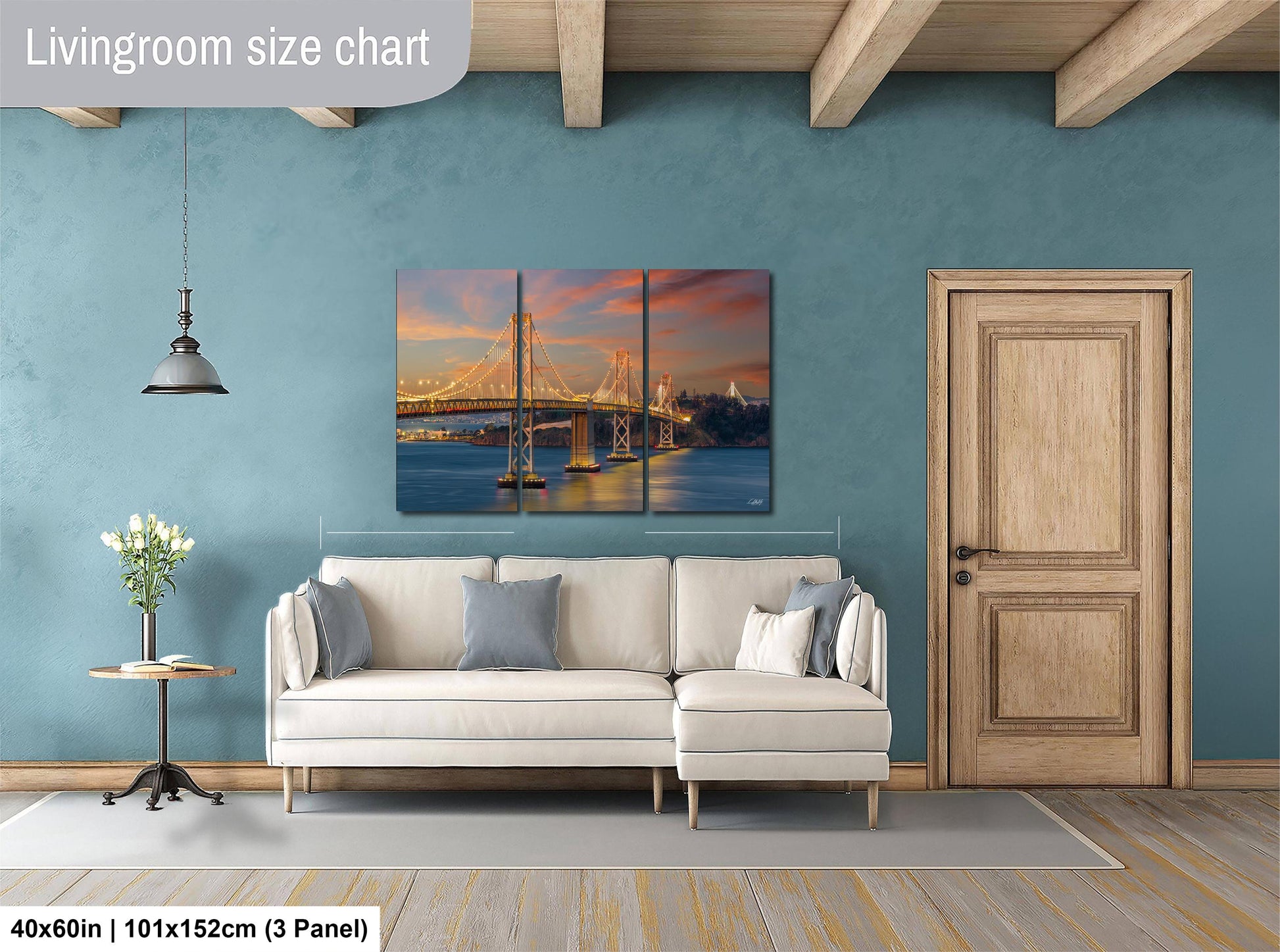 a living room with a large, colorful painting of a bridge hanging on the wall. The painting is divided into three panels, creating a collage-like effect. The room has a white sofa, a wooden door, and a small table with a vase of flowers. The walls are painted a light blue color, and the floor is covered with a gray rug.