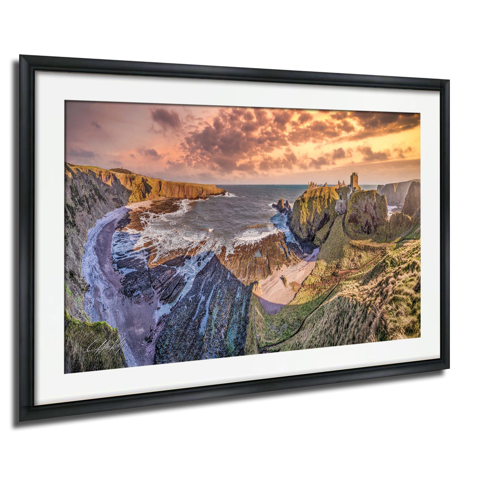 The image is a framed photograph of a scenic coastal landscape with cliffs, a rocky shoreline, and a body of water in the background. The sky is filled with clouds, and the colors in the image are vibrant, creating a picturesque and serene atmosphere.