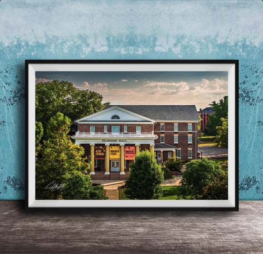 A framed photograph of the Peabody Hall building, a historic brick structure with a prominent pediment and columns, surrounded by trees and a blue sky.
