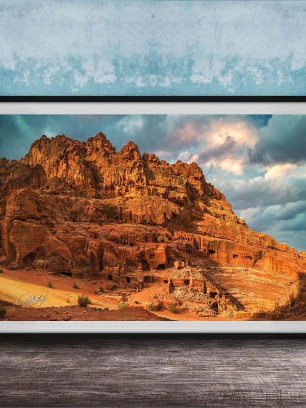 a large, rocky cliff with a dramatic sky in the background.
