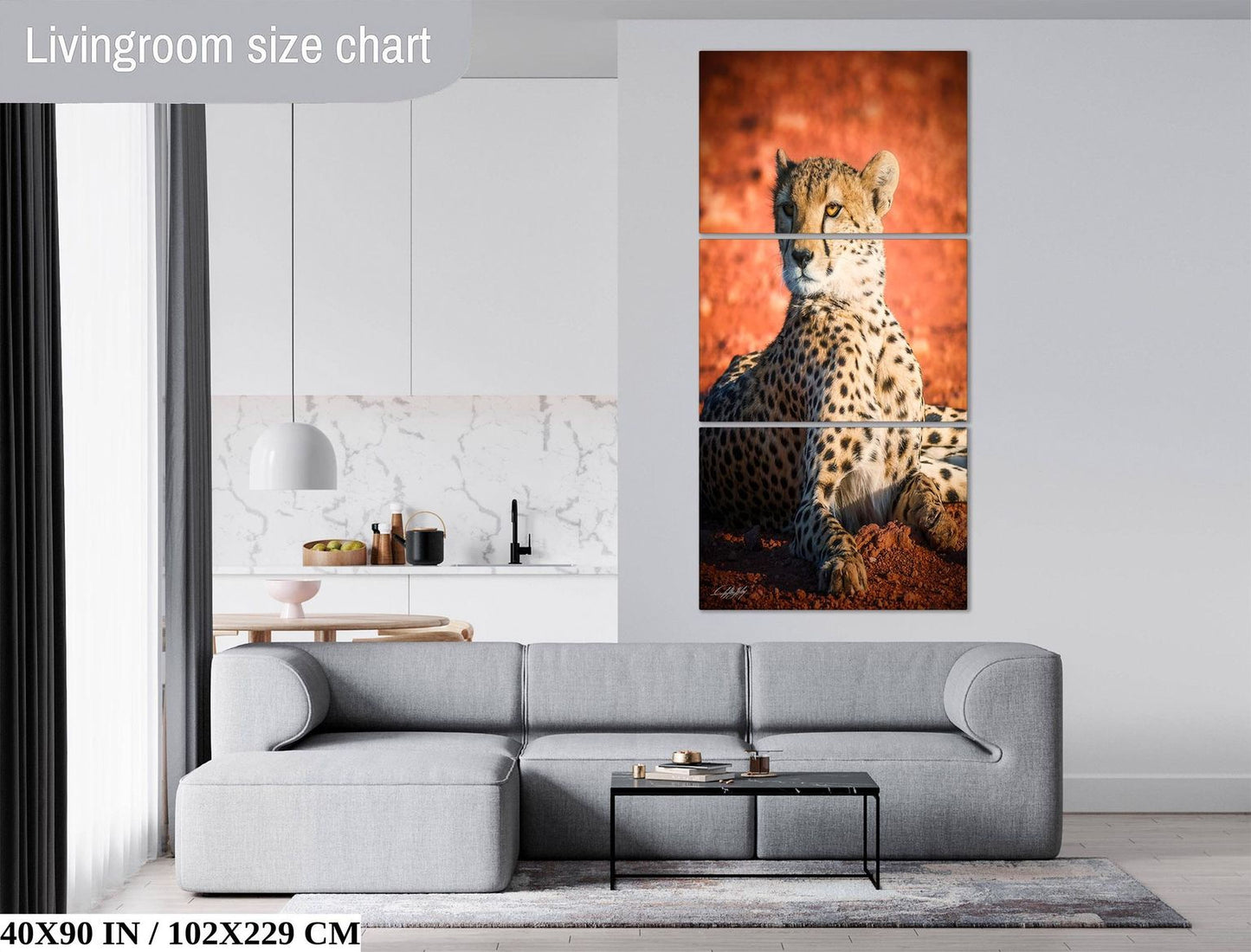 The image is a living room with a gray sofa and a coffee table. There is a large wall art depicting a cheetah sitting on the ground. The wall art is framed and hangs above the sofa.