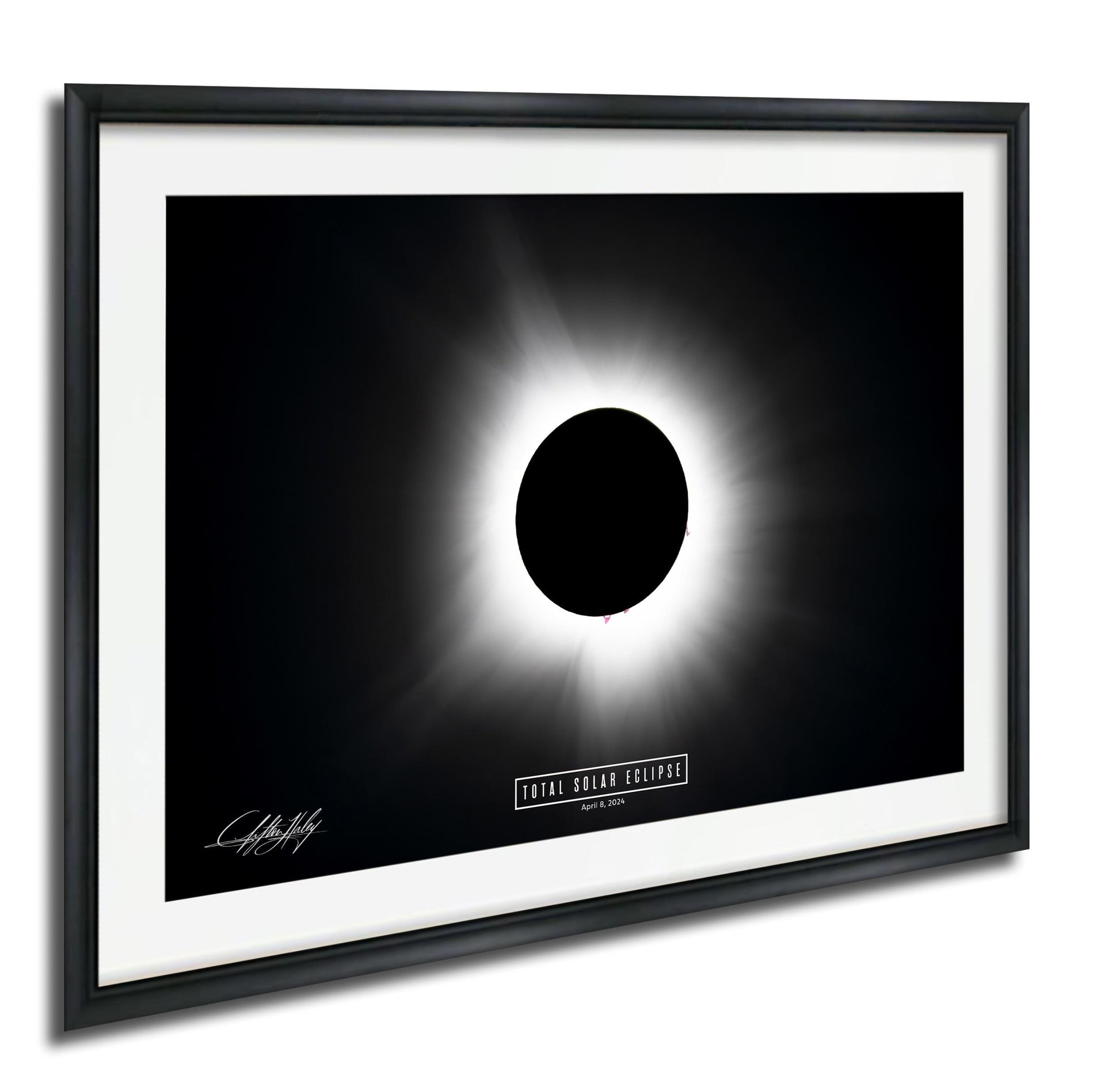The image is a framed photograph depicting a total solar eclipse, with the moon completely obscuring the sun and creating a bright, white ring around it.