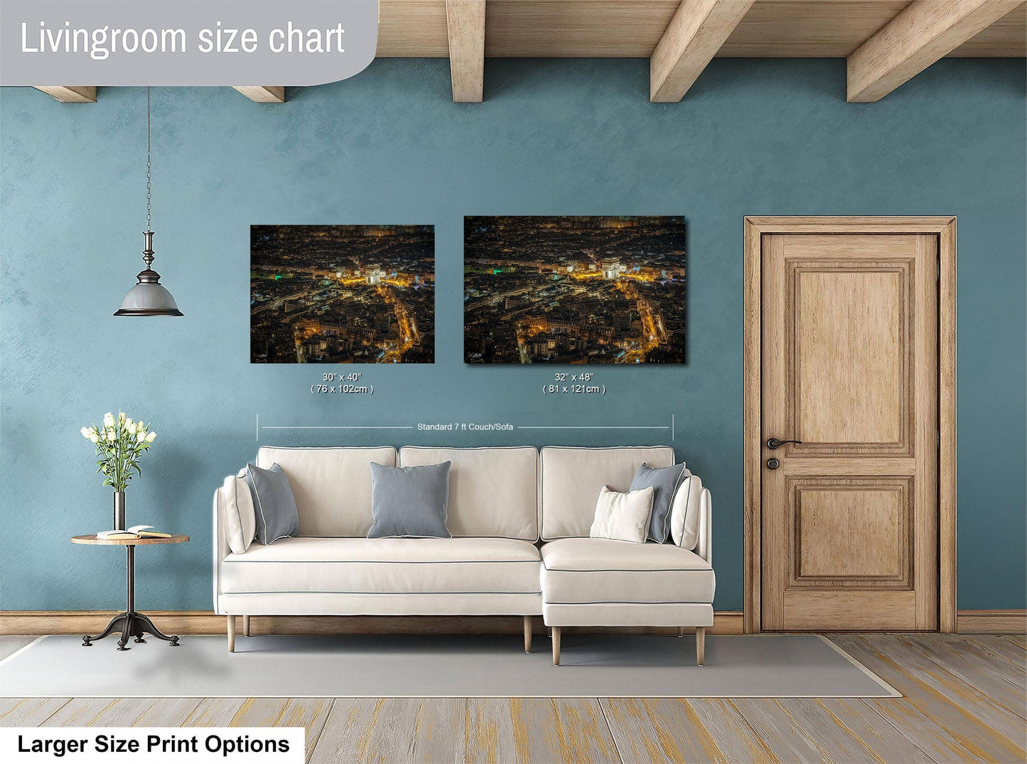 a living room with a white sofa, a wooden door, and two framed pictures hanging on the wall.