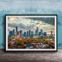 A framed aerial view of the skyline of a city, with tall buildings and skyscrapers against a cloudy sky.
