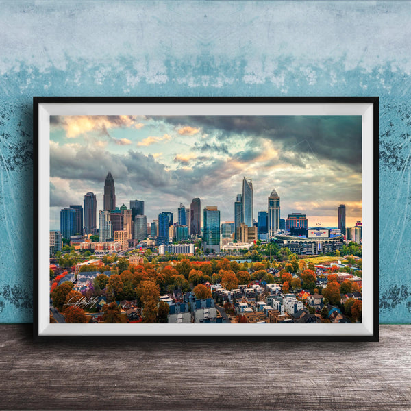 A framed aerial view of the skyline of a city, with tall buildings and skyscrapers against a cloudy sky.