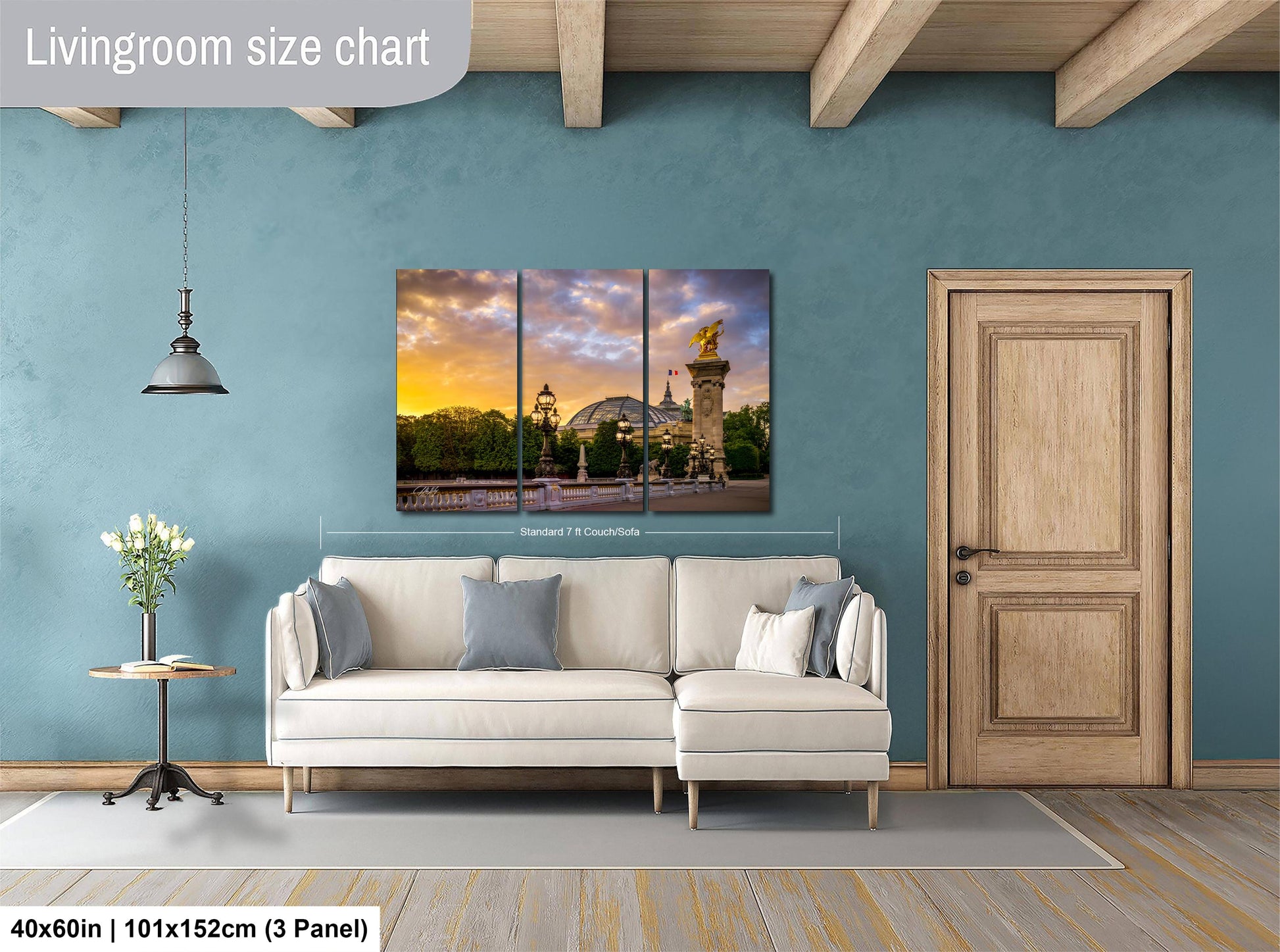 The image is a living room with a large, three-panel living room size chart on the wall. The chart displays the dimensions of the living room in centimeters, with the largest panel being 40x60 inches (101x152 cm) and the smallest panel being 40x60 inches (101x152 cm). The living room also includes a white sofa, a wooden door, and a vase of flowers on a table.