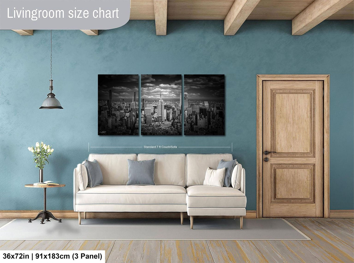 The image is a living room with a large city skyline painting hanging on the wall. The painting is divided into three panels, and the room has a white sofa, a wooden door, and a small table with a vase of flowers.