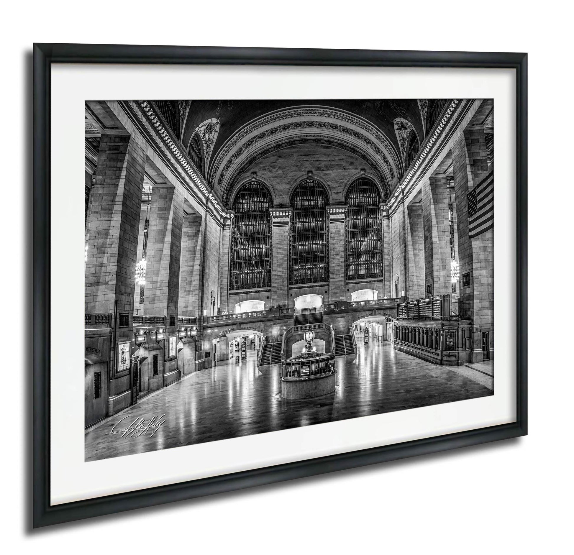 The image is a black and white photograph of a grand, ornate interior space with high ceilings, arched windows, and columns. The photograph is framed and displayed on a wall.