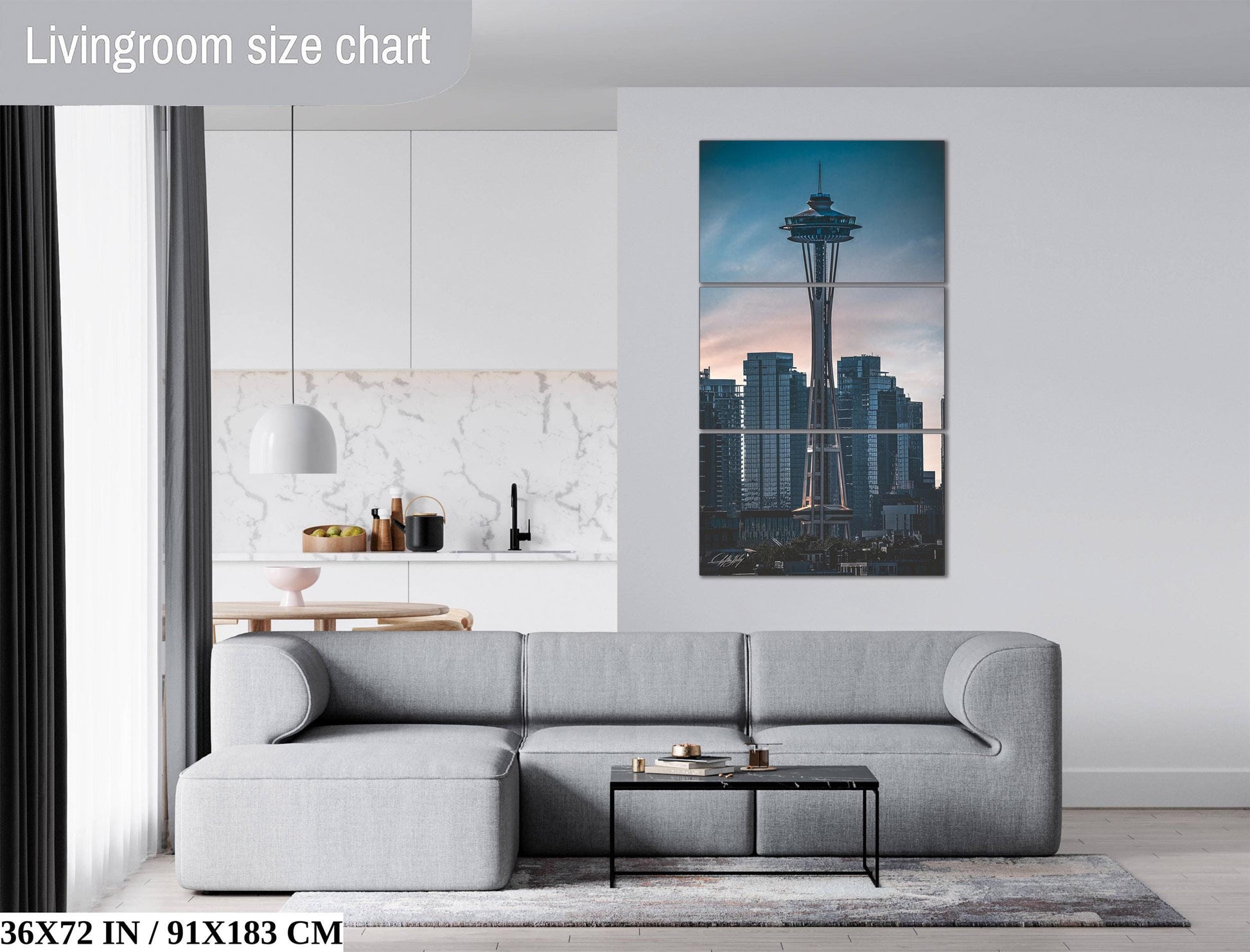 The image is a living room with a gray sofa, a coffee table, and a large wall art depicting the Space Needle in Seattle, Washington.