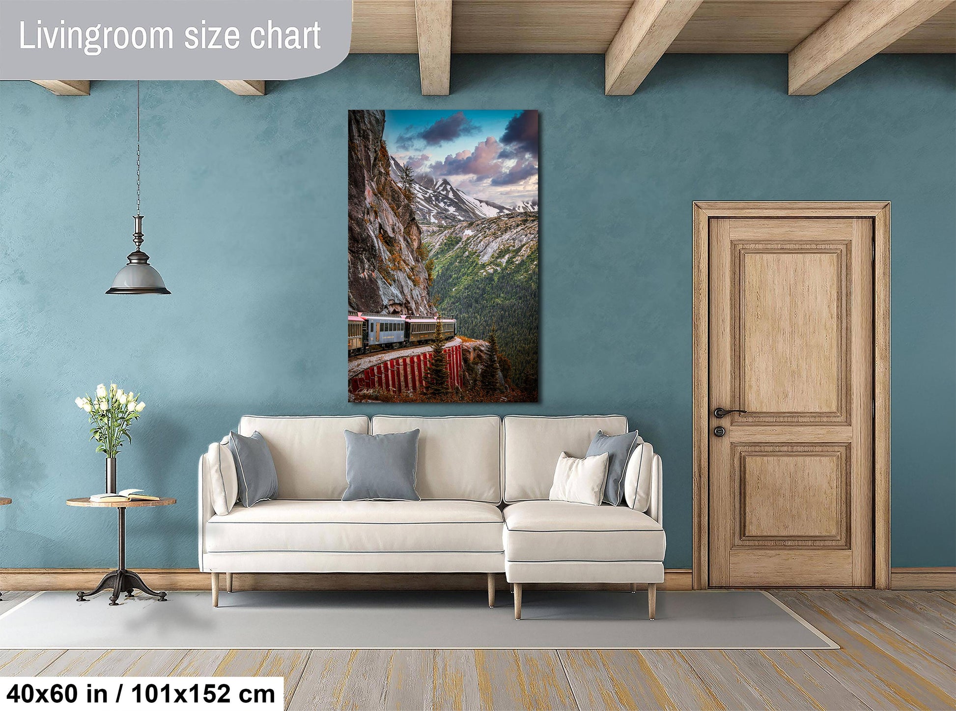 a living room with a large white sofa, a wooden door, and a painting of a mountain landscape hanging on the wall.