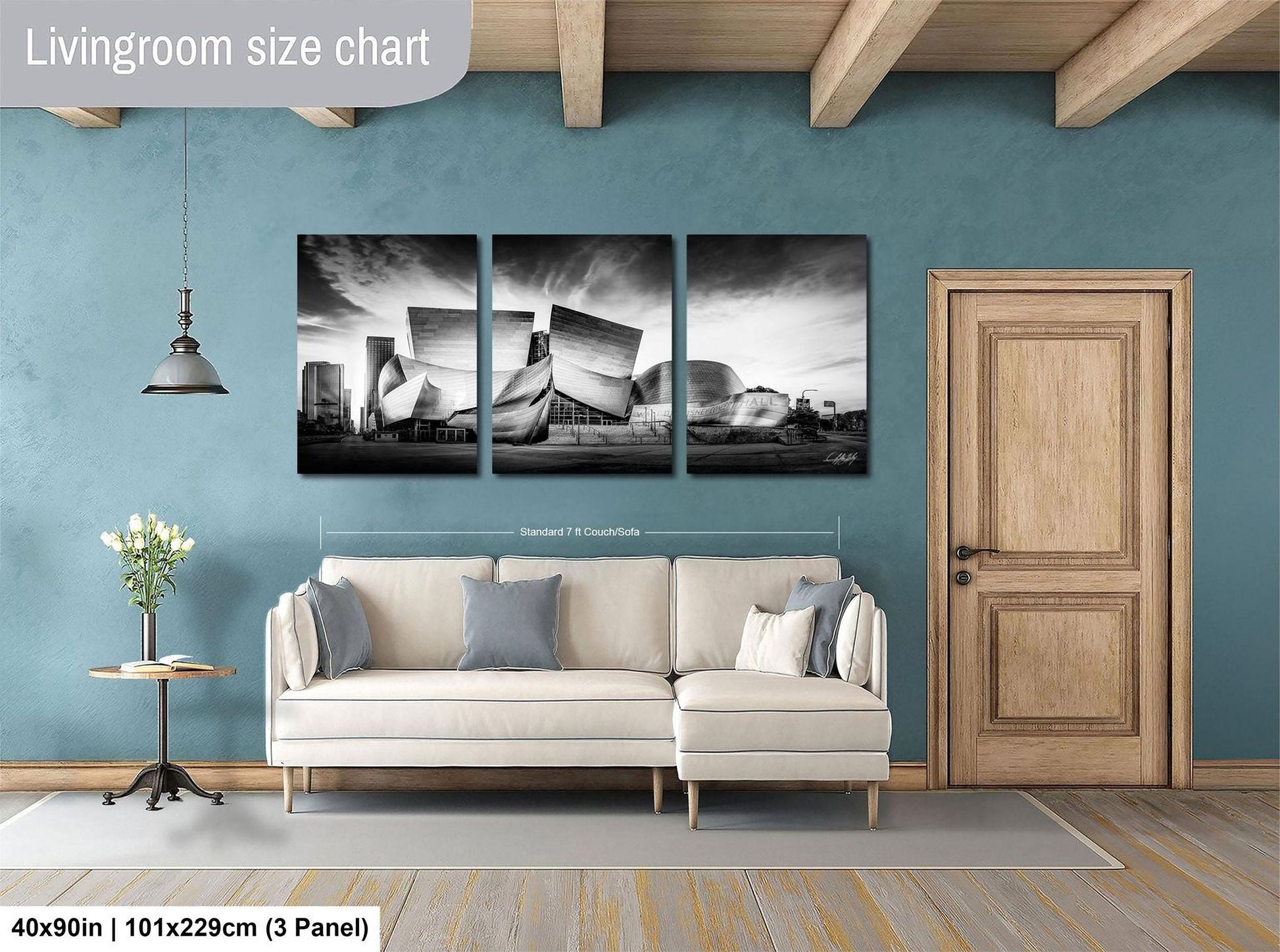 The image is a living room with a large wall art piece depicting a building, a sofa, and a wooden door.