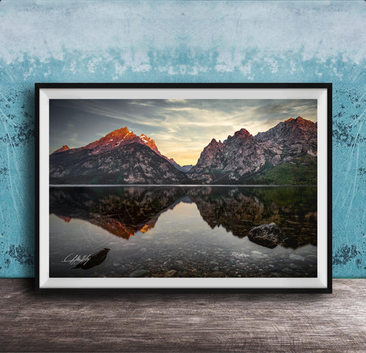 a serene mountain landscape with a calm lake reflecting the mountains and sky.