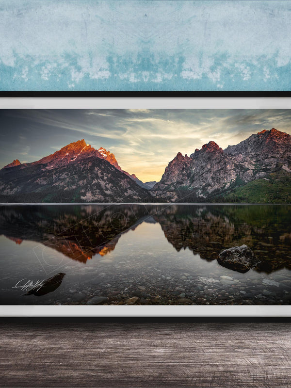 a serene mountain landscape with a calm lake reflecting the mountains and sky.