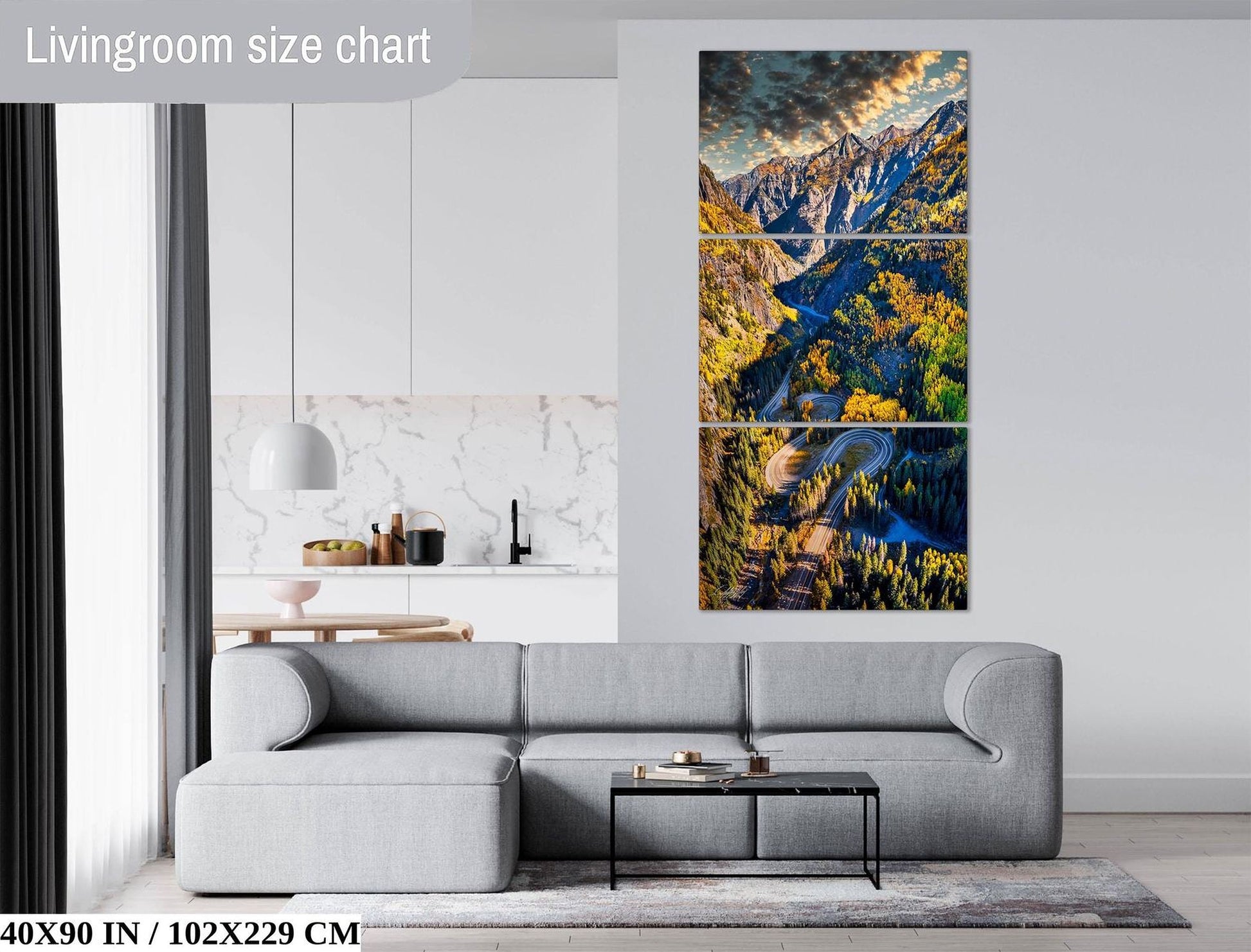 The image is a living room with a gray sofa, a coffee table, and a large wall art depicting a scenic mountain landscape.