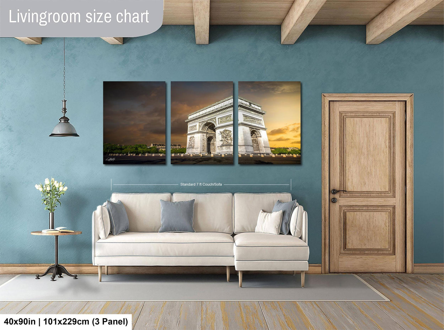 The image is a living room with a large wall art piece depicting the Arc de Triomphe in Paris. The wall art is divided into three panels, each showing different angles of the iconic monument. The living room has a white sofa and a wooden door, creating a cozy and inviting atmosphere.