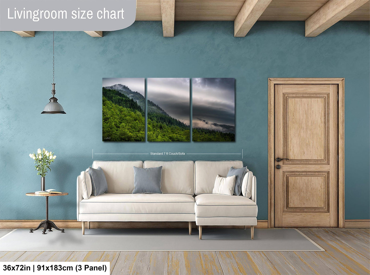 The image is a living room with a large wall art depicting a mountain landscape. The wall art is divided into three panels, with the largest panel covering the entire wall. The room features a white sofa, a wooden door, and a small table with a vase of flowers. The living room size chart indicates that the space is approximately 36 square meters.