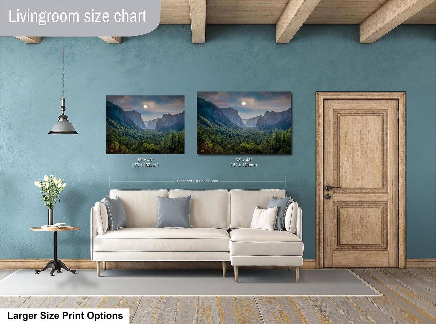 a living room with a white sofa, a wooden door, and two framed landscape paintings hanging on the wall.