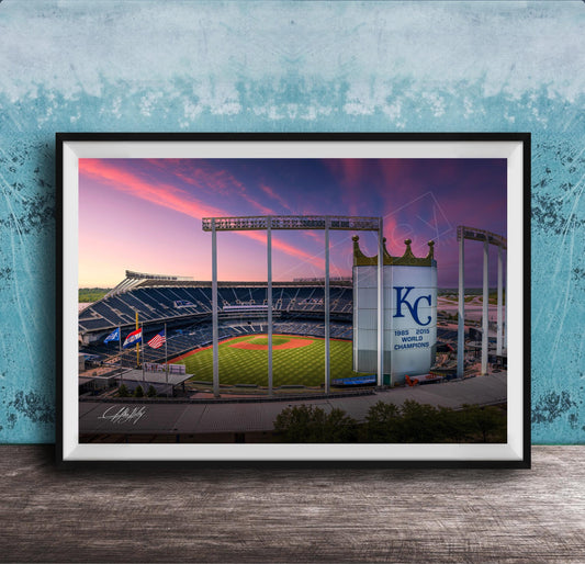 A framed photograph of a baseball stadium at sunset, with the Kansas City Royals logo prominently displayed.