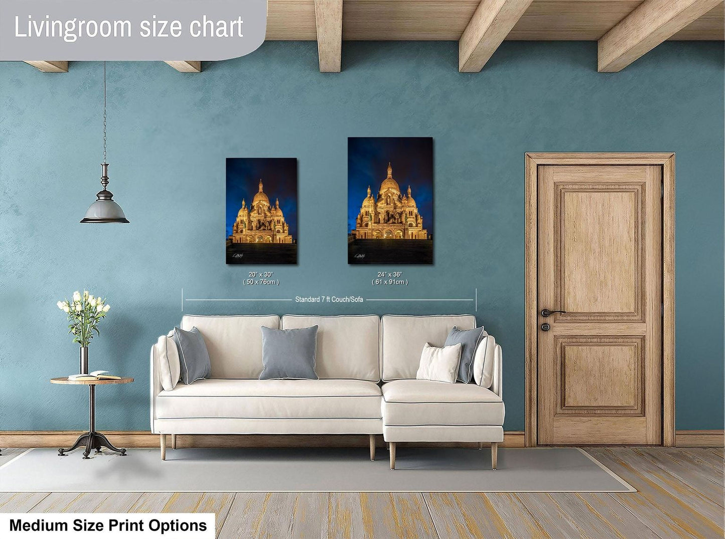 a living room with a white sofa, a wooden door, and a framed picture of a cathedral on the wall.