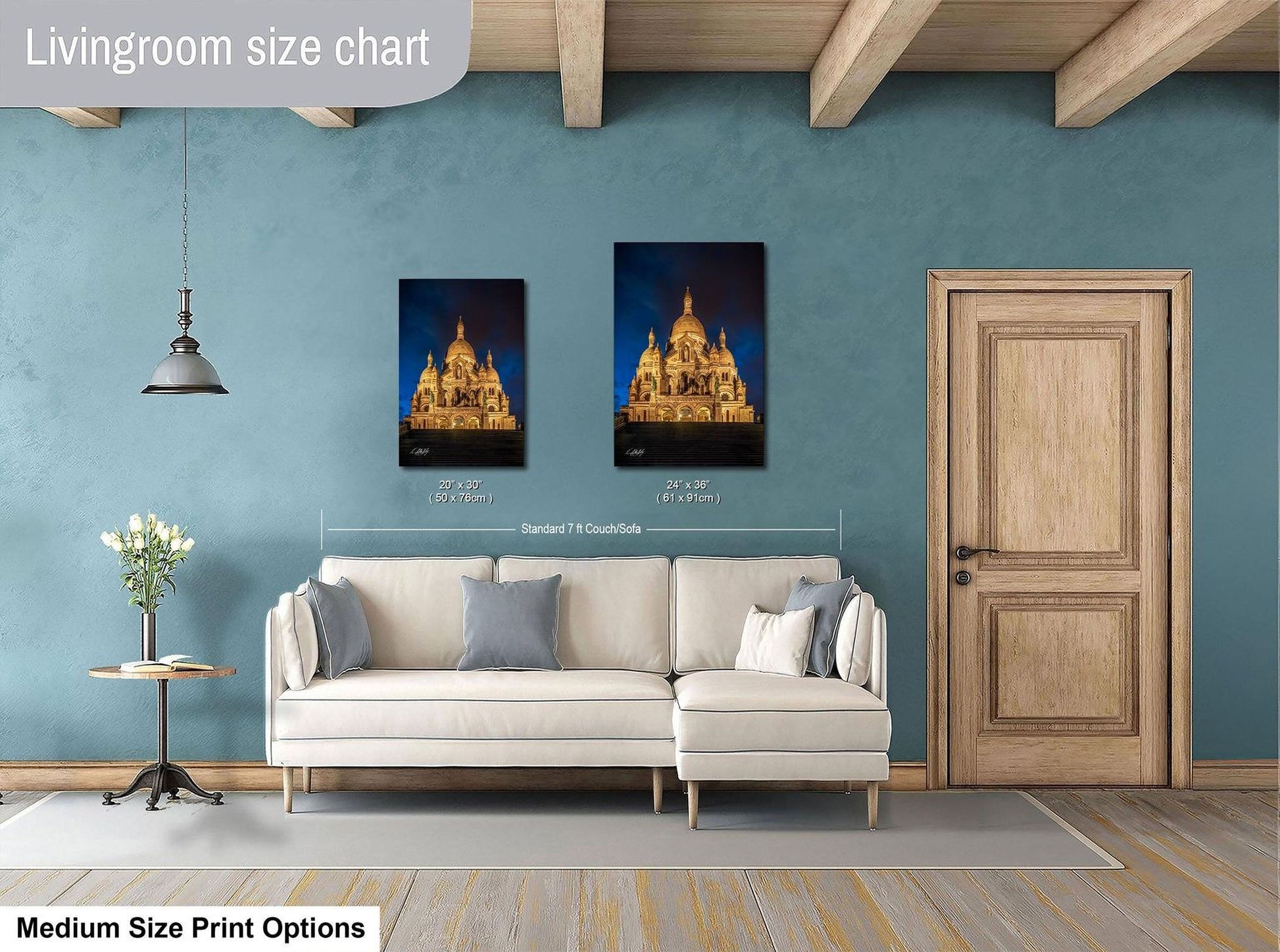 a living room with a white sofa, a wooden door, and a framed picture of a cathedral on the wall.