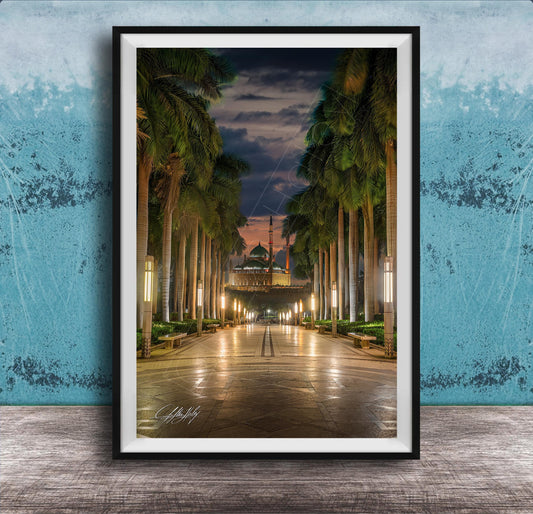 A framed photograph depicting a serene nighttime scene of a palm-lined walkway leading towards a building with a dome, illuminated by warm lighting.