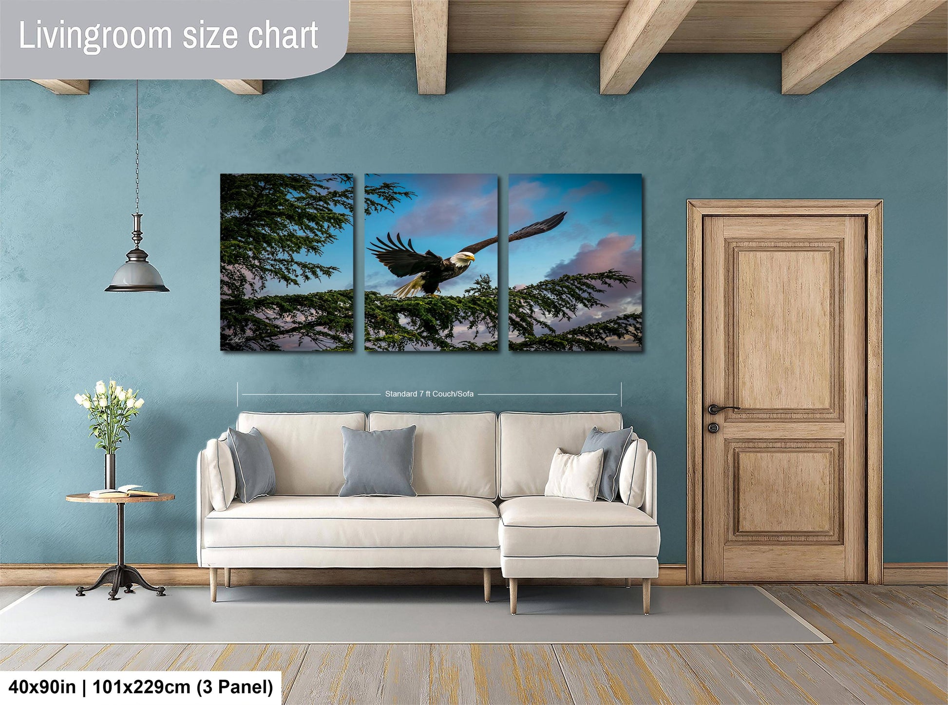 The image is a living room with a large white sofa, a wooden door, and a painting of a bird in flight on the wall.