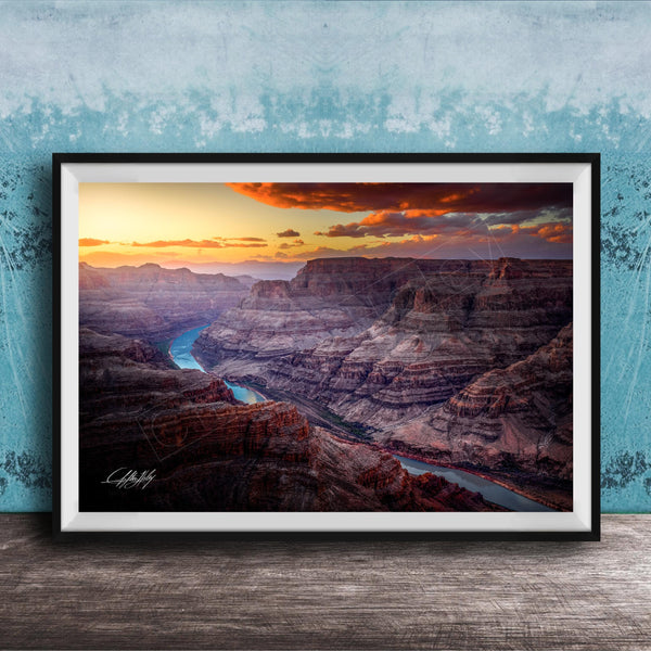 A framed photograph of a breathtaking view of the Grand Canyon, with a stunning sunset over the rugged, layered rock formations.