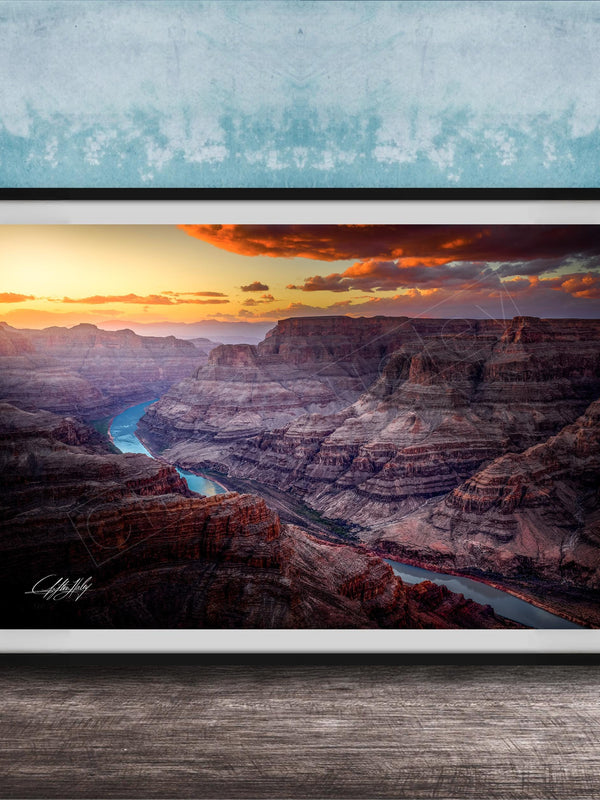 A framed photograph of a breathtaking view of the Grand Canyon, with a stunning sunset over the rugged, layered rock formations.