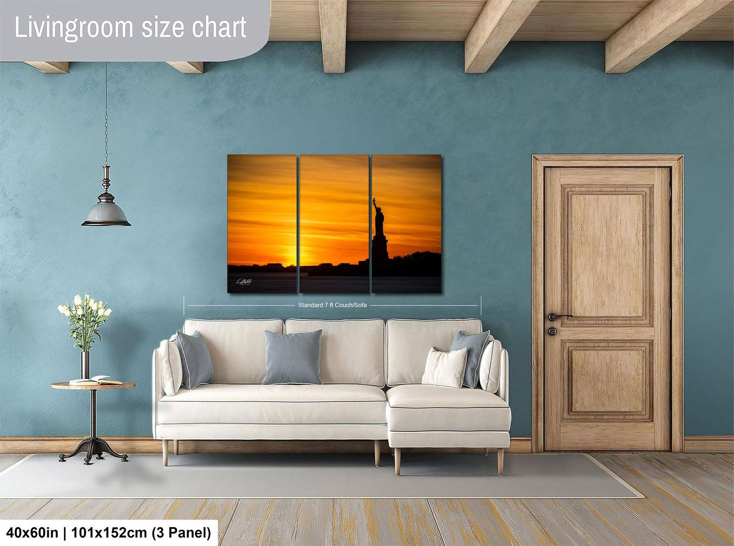 The image is a living room with a large wall art depicting a sunset over the Statue of Liberty. The room is furnished with a white sofa and a wooden door.