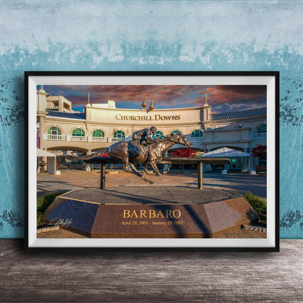 A bronze statue of a horse and jockey racing on a track, with the name "Barbario" displayed below the statue. The background shows a large building with the name "Churchill Downs" written on it.