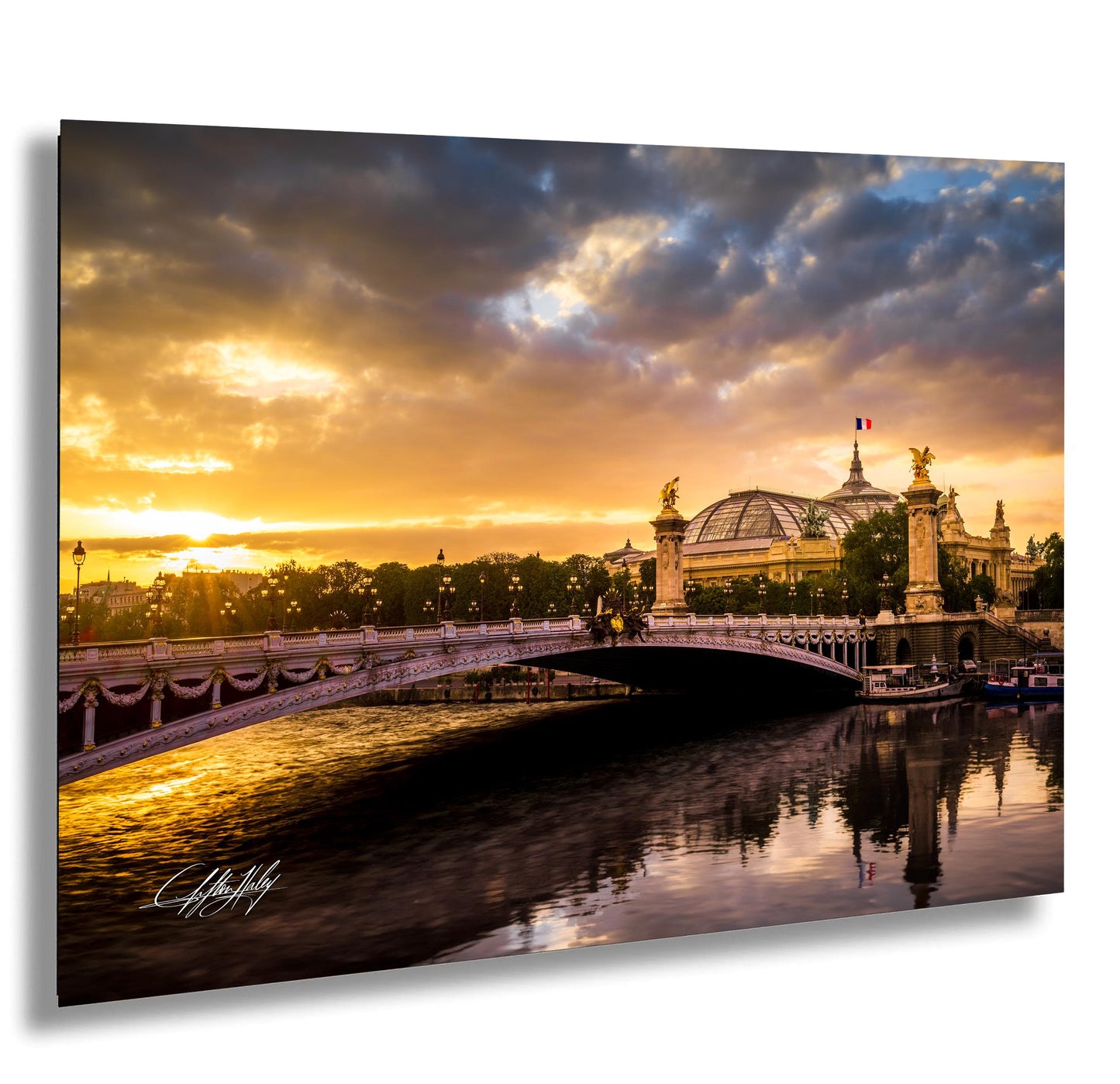 a picturesque scene of a bridge spanning a river, with a large domed building in the background and a stunning sunset casting a warm glow over the entire landscape.
