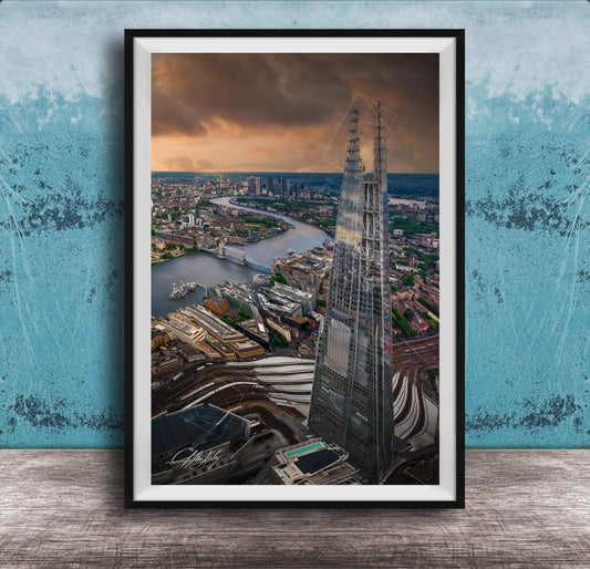 The image is a framed aerial view of the London skyline, showcasing the iconic Shard skyscraper and the River Thames in the background.