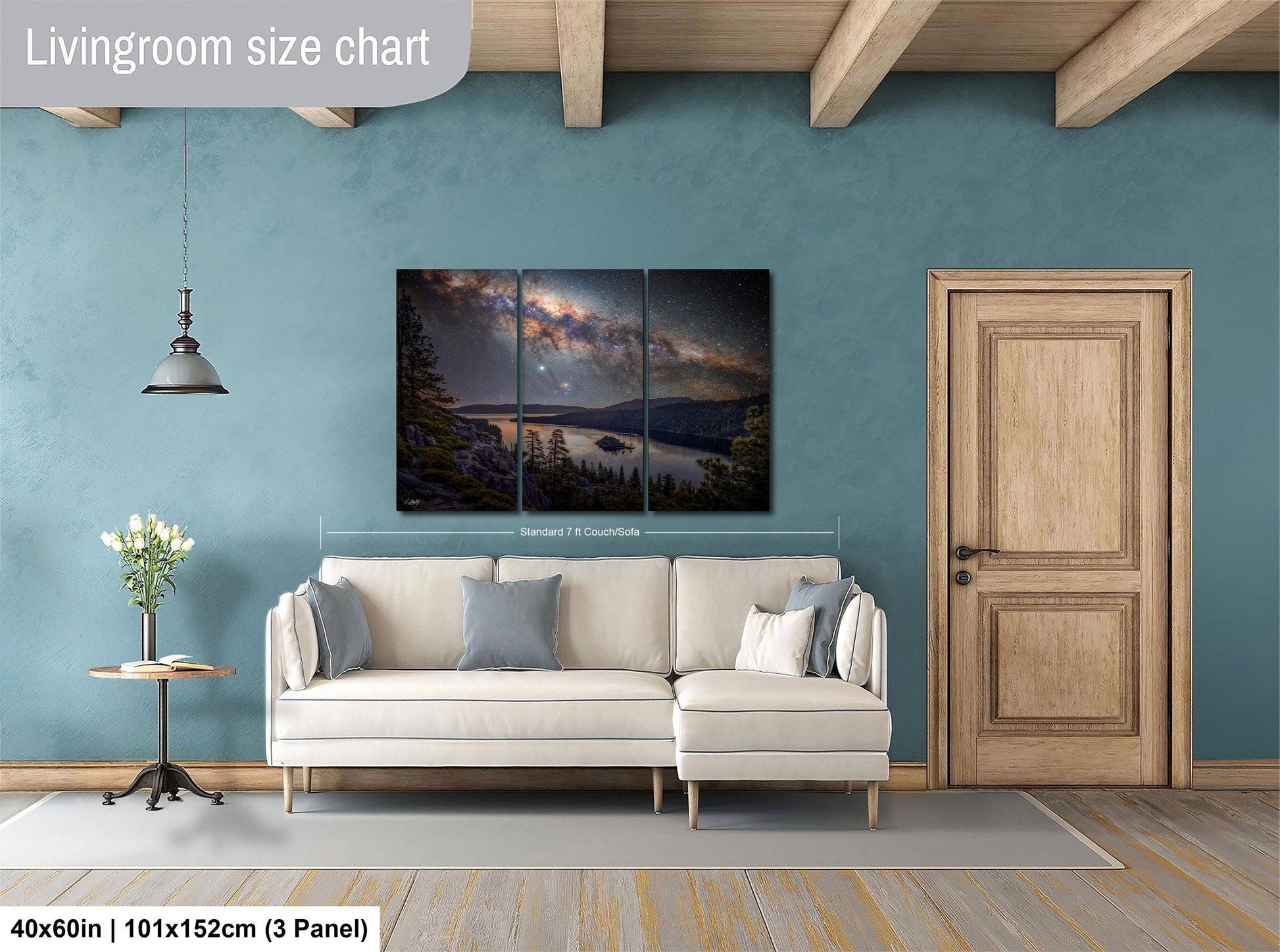 The image is a living room with a large painting of a night sky over a lake hanging on the wall. The painting is divided into three panels, and the living room has a white sofa, a wooden door, and a small table with a vase of flowers.