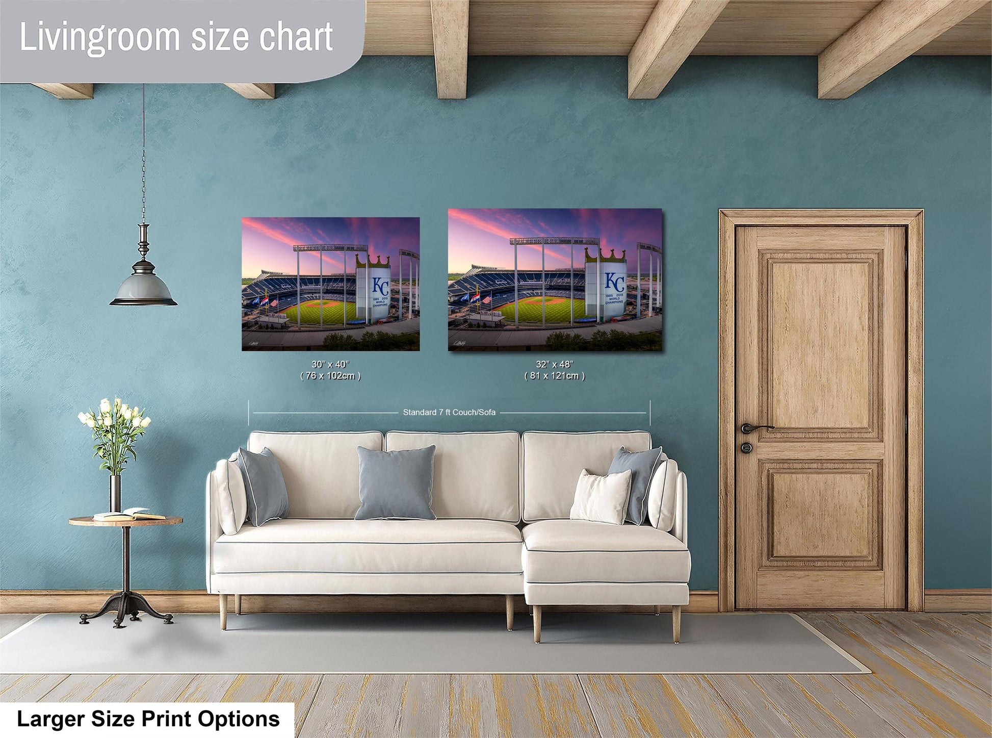 a living room with a white sofa and a wooden door. Above the sofa, there are two framed pictures of a baseball stadium, with one picture being larger than the other. The living room has a blue wall and a wooden ceiling.