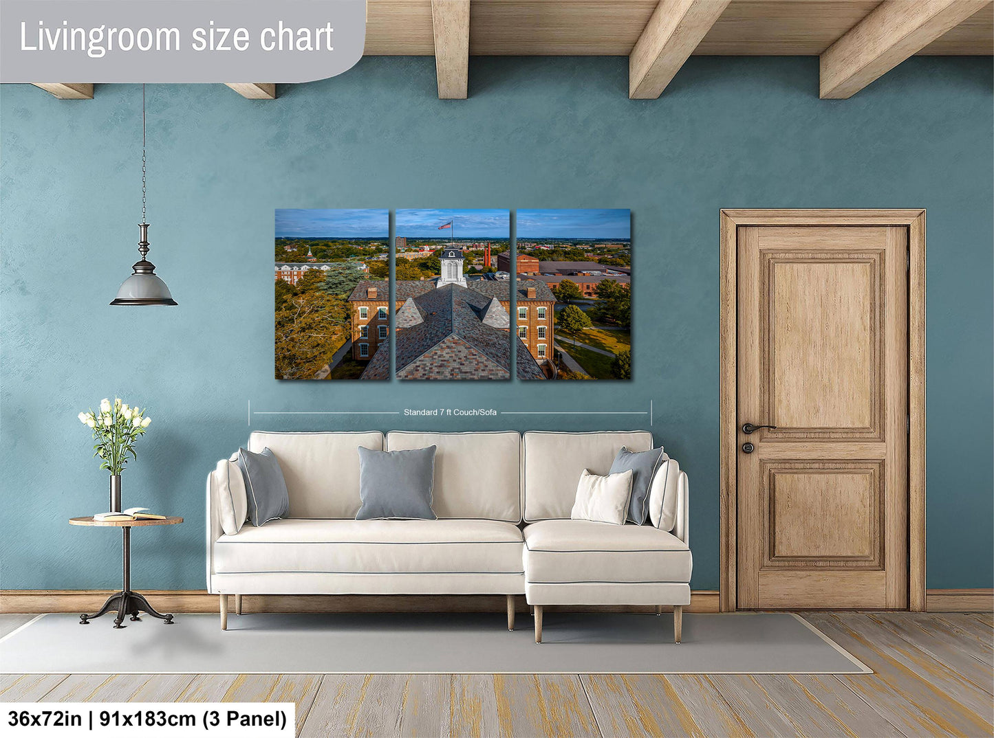 The image is a living room with a large white sofa, a wooden door, and a hanging light fixture. Above the sofa, there is a large living room size chart that provides dimensions for the artwork displayed on the wall.