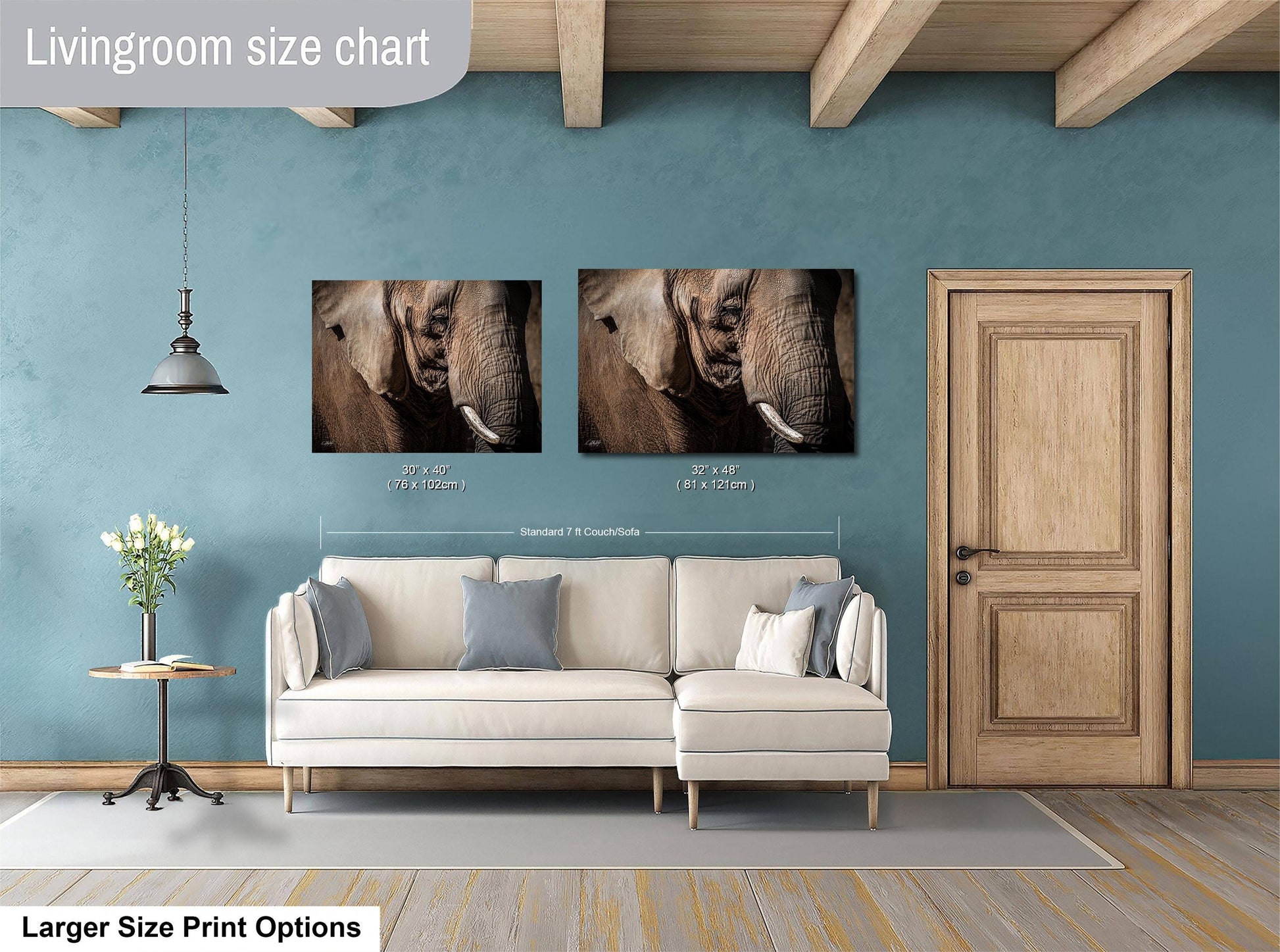 a living room with a white sofa, a wooden door, and two framed photographs of elephants on the wall.